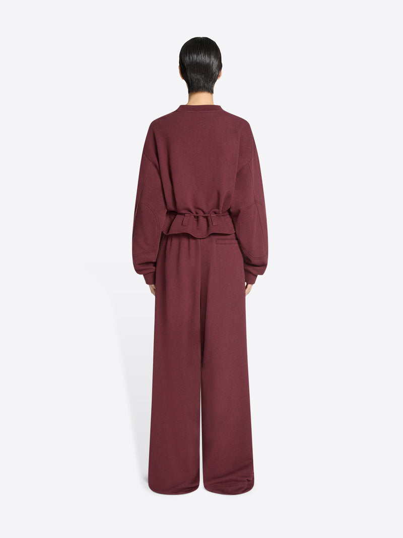 Back view of a person wearing a burgundy set on a white background