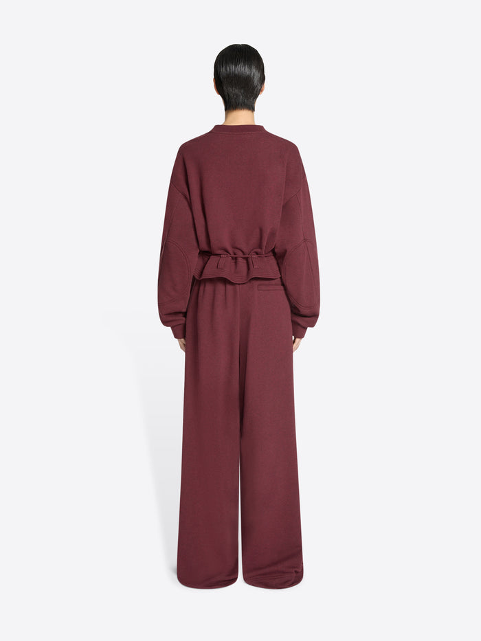 Back view of a person wearing a burgundy set on a white background