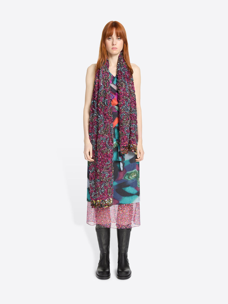 Woman wearing a colorful dress and scarf on a white background