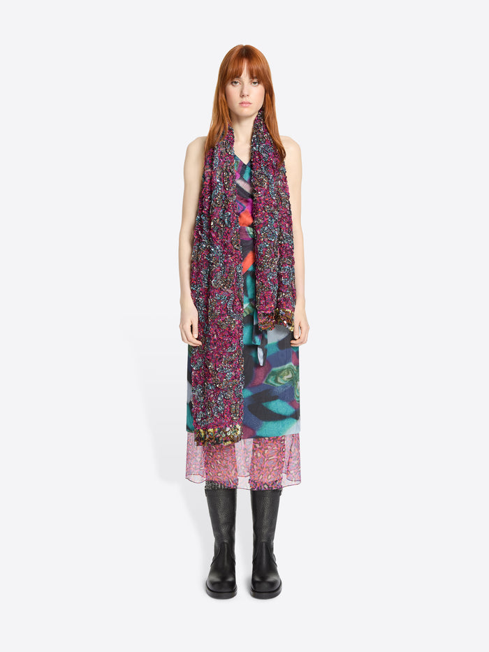 Woman wearing a colorful dress and scarf on a white background