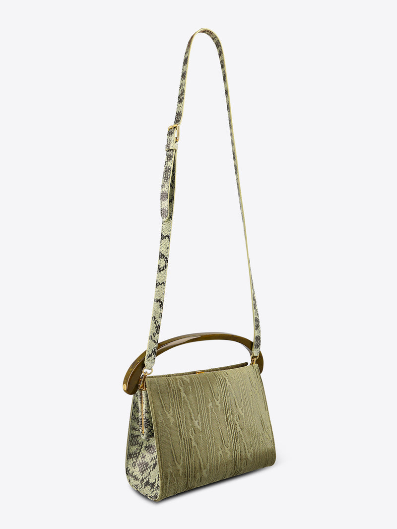 Green handbag with a patterned strap on a white background