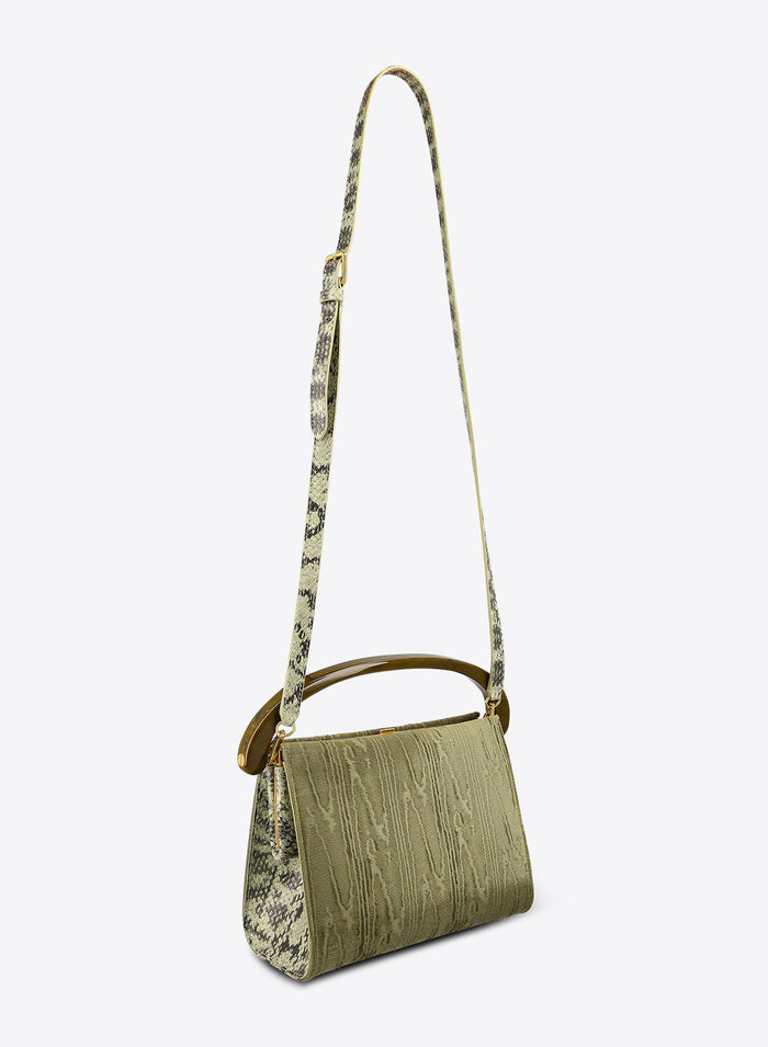 Green handbag with a patterned strap on a white background