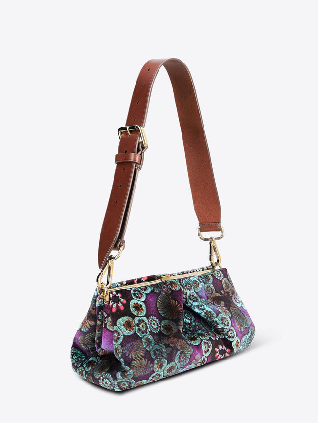 Multicolored patterned handbag with a brown strap on a white background