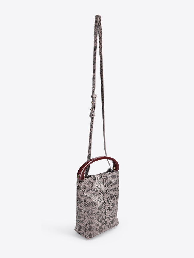 Small handbag with a snake print body and burgundy handle on a white background