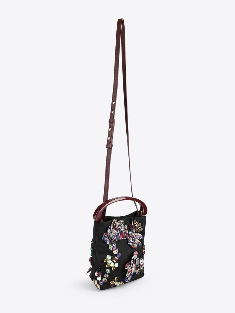 Floral embroidered handbag with a strap on a white background