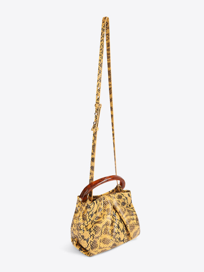 Yellow patterned handbag with a brown handle on a white background