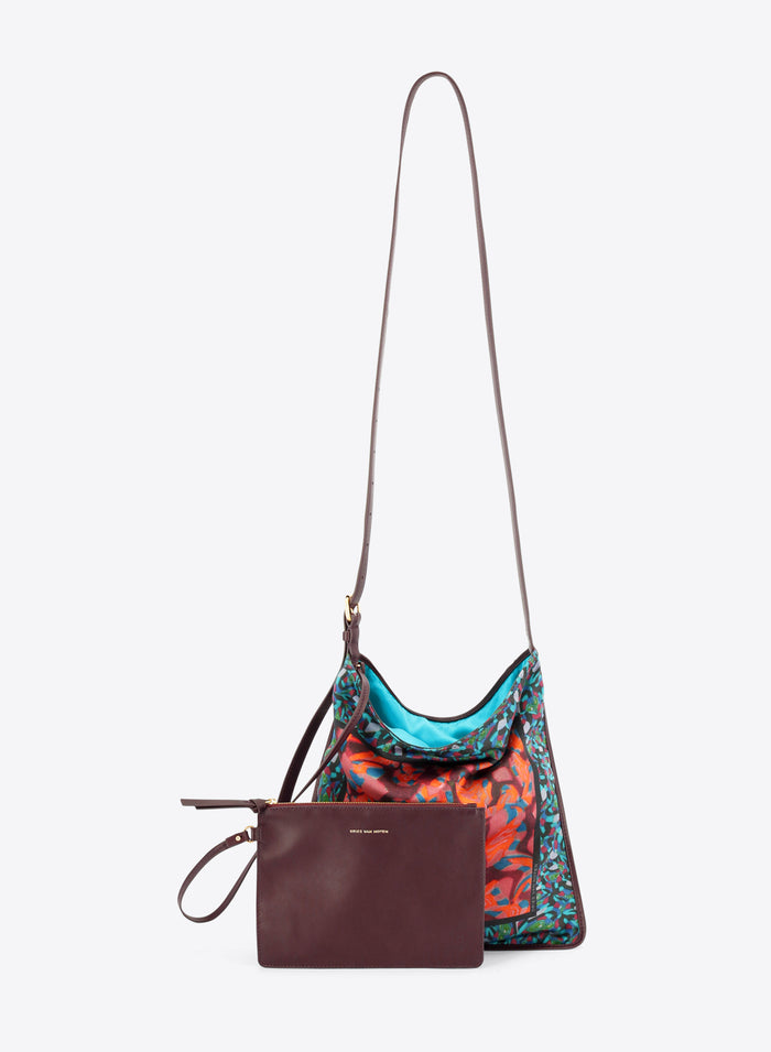 Multicolored patterned handbag with a matching burgundy pouch on a white background