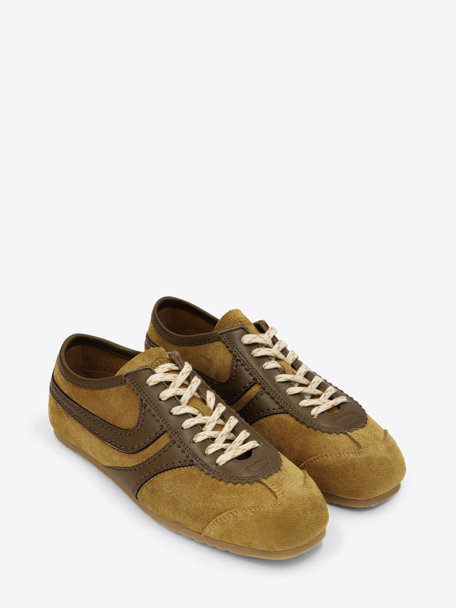 Pair of mustard yellow and brown suede shoes on a white background