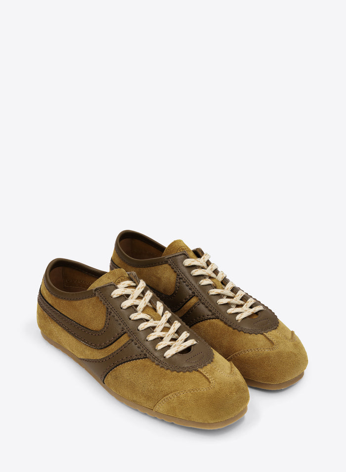Pair of mustard yellow and brown suede shoes on a white background