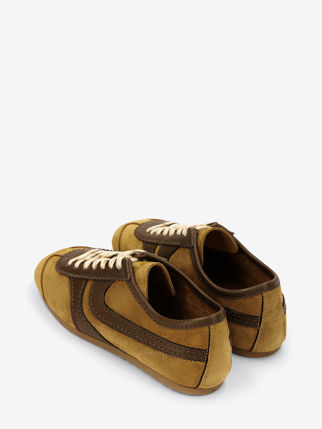 Pair of mustard yellow and brown suede shoes on a white background