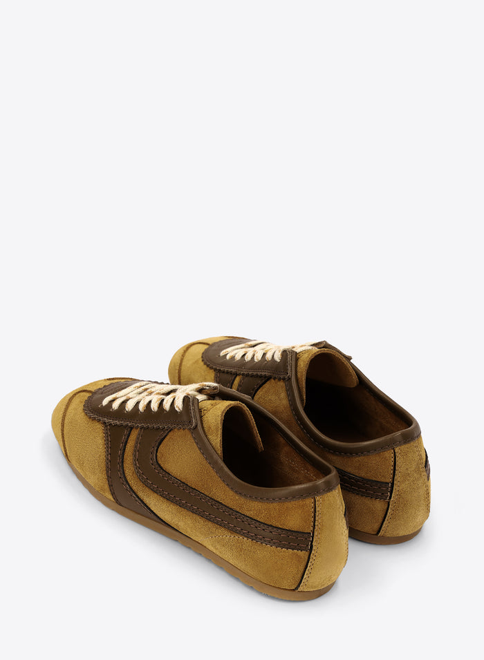 Pair of mustard yellow and brown suede shoes on a white background