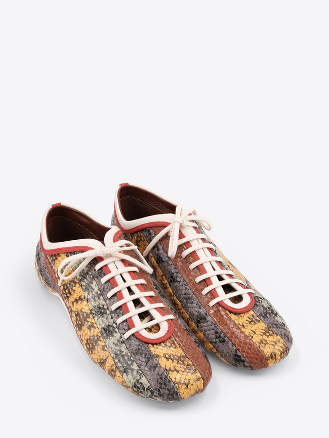 Pair of patterned sneakers with white laces on a light gray background