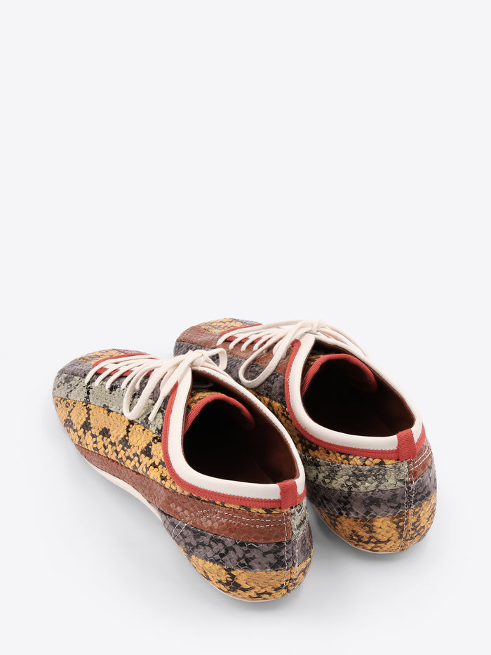 Pair of patterned sneakers with white laces on a light gray background