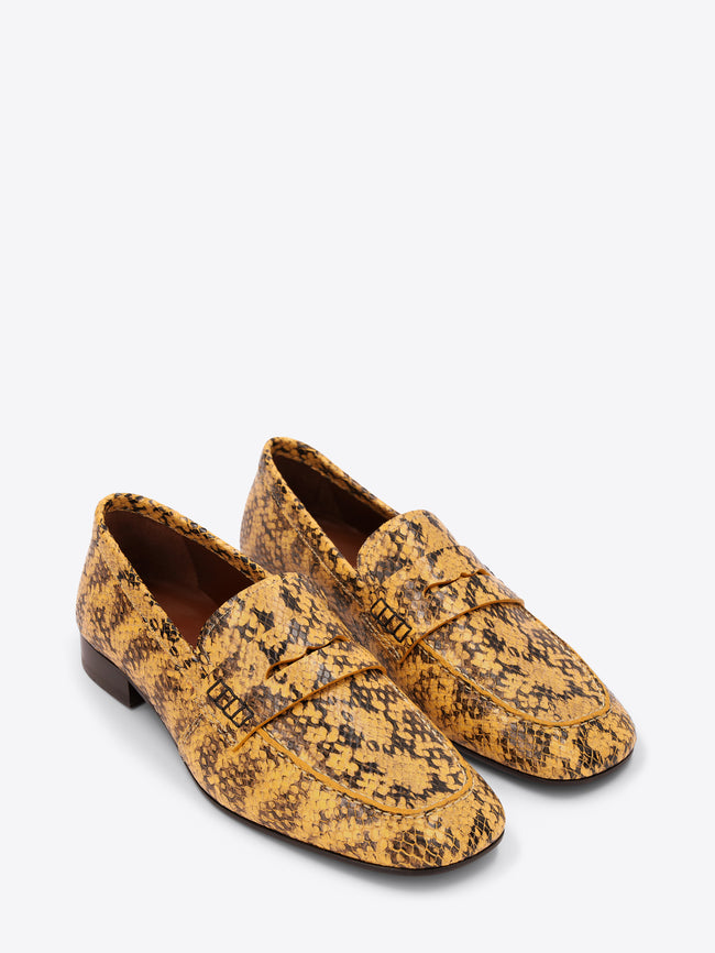 Pair of yellow patterned loafers on a white background