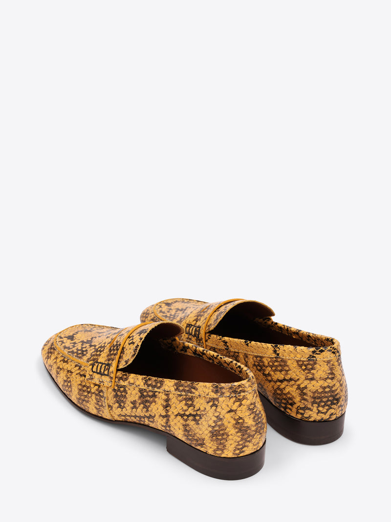 Pair of yellow patterned loafers on a white background