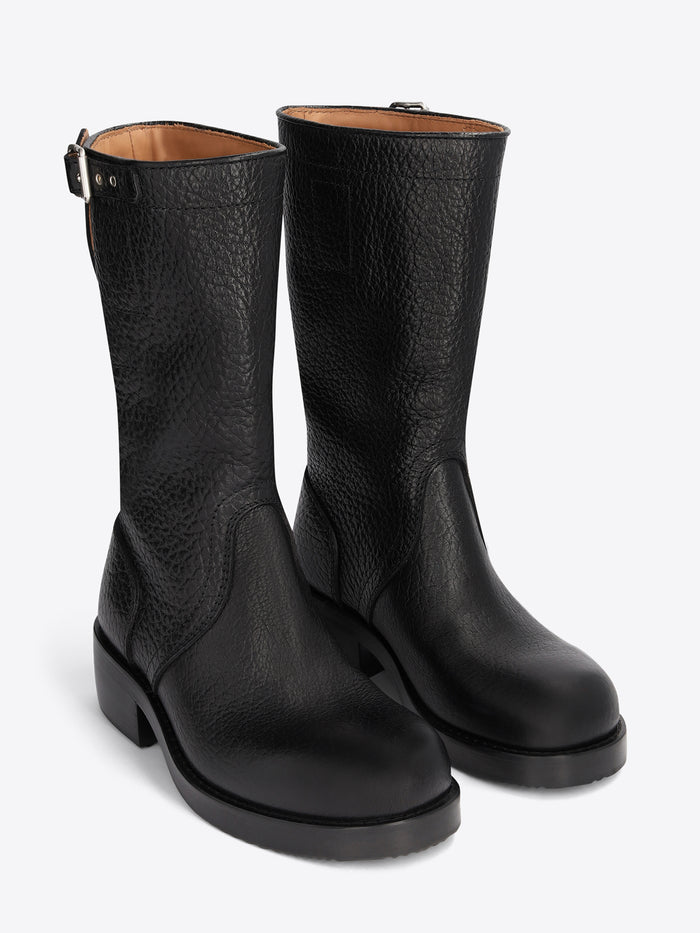 Pair of black leather boots on a light grey background
