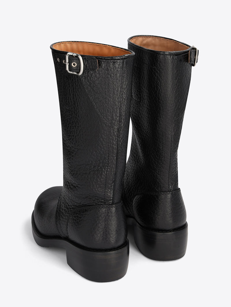 Pair of black leather boots on a light grey background