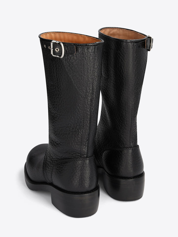 Pair of black leather boots on a light grey background