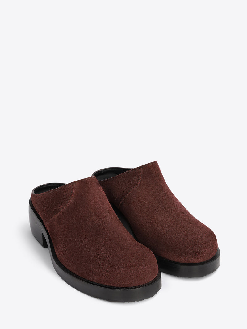 Brown clog shoes on a light grey background