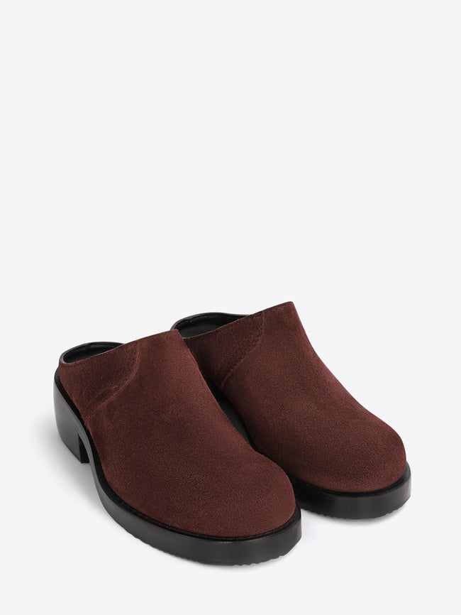 Brown clog shoes on a light grey background