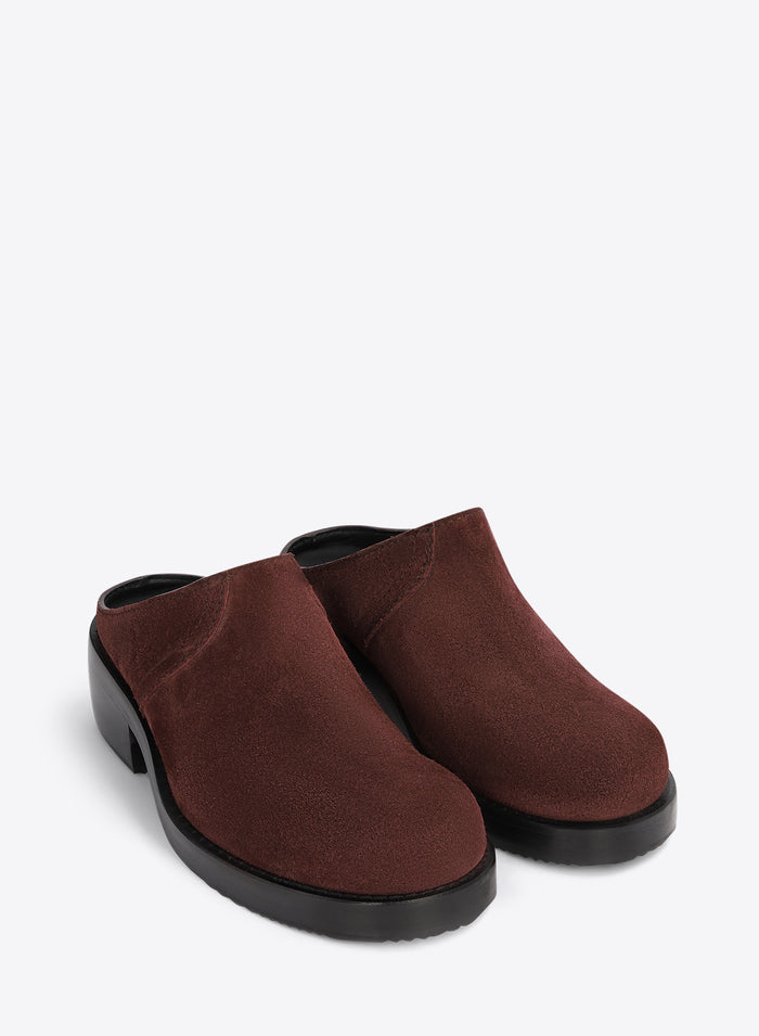 Brown clog shoes on a light grey background