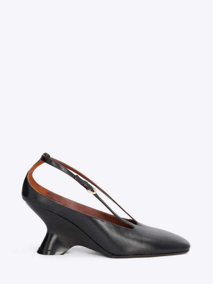 A black leather slingback pump with a low block heel and a thin strap detail across the instep, shown from a side profile on a light gray background.