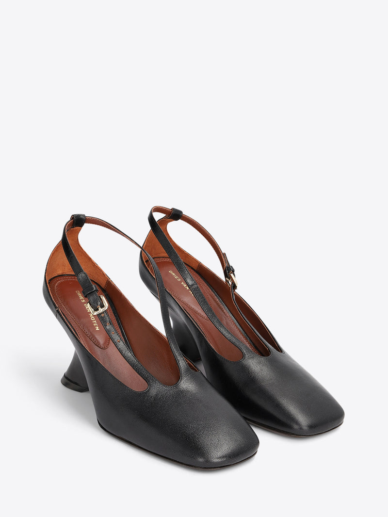 A pair of black leather slingback pumps with a low block heel and a thin strap detail across the instep on a light gray background.