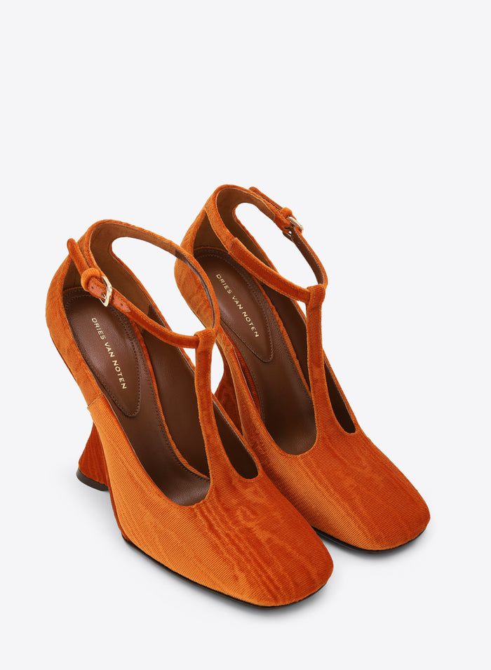 Pair of orange high-heeled shoes on a white background