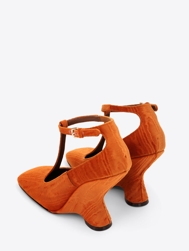 Pair of orange high-heeled shoes on a white background
