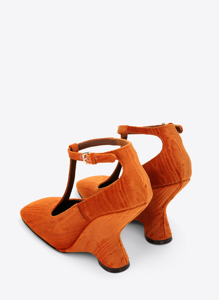 Pair of orange high-heeled shoes on a white background