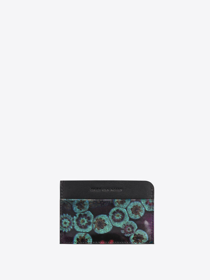 A slim card holder wallet, featuring a black leather top band and a lower section with a teal and purple floral pattern, shown on a light gray background.