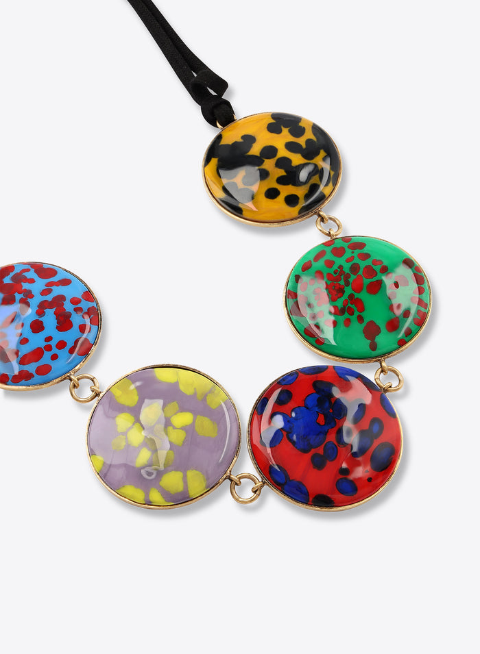 Multicolored circular pendants on a black cord against a white background