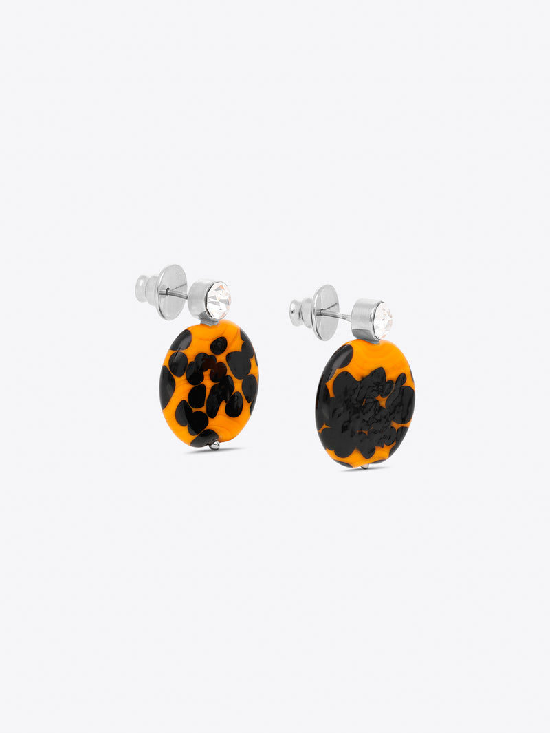 Pair of earrings with black and orange pattern on a white background