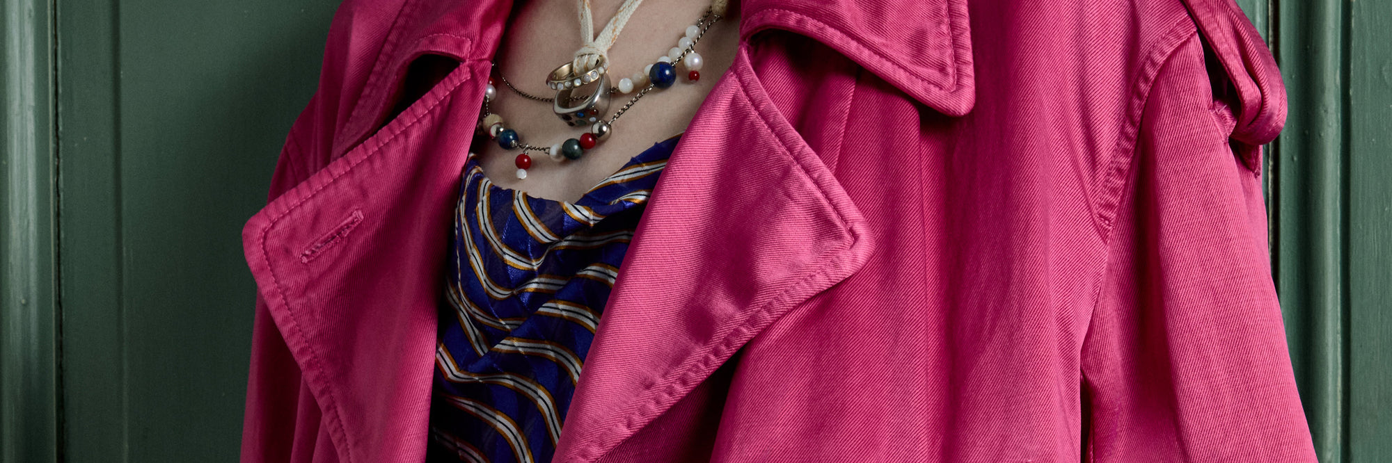 Pink jacket over a blue patterned top against a green background - Dries Van Noten