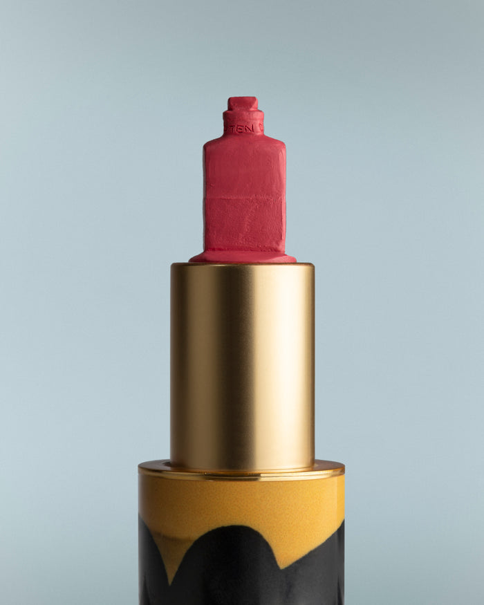 Lipstick with gold and black casing on a gray background