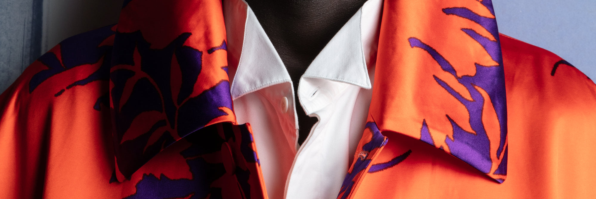 Orange fabric with purple abstract patterns draped over a white shirt - Dries Van Noten.