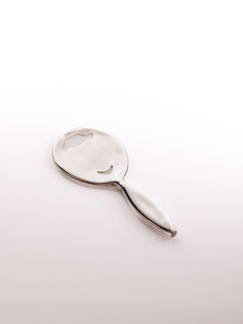 Clear glass object with an oval shape and a handle