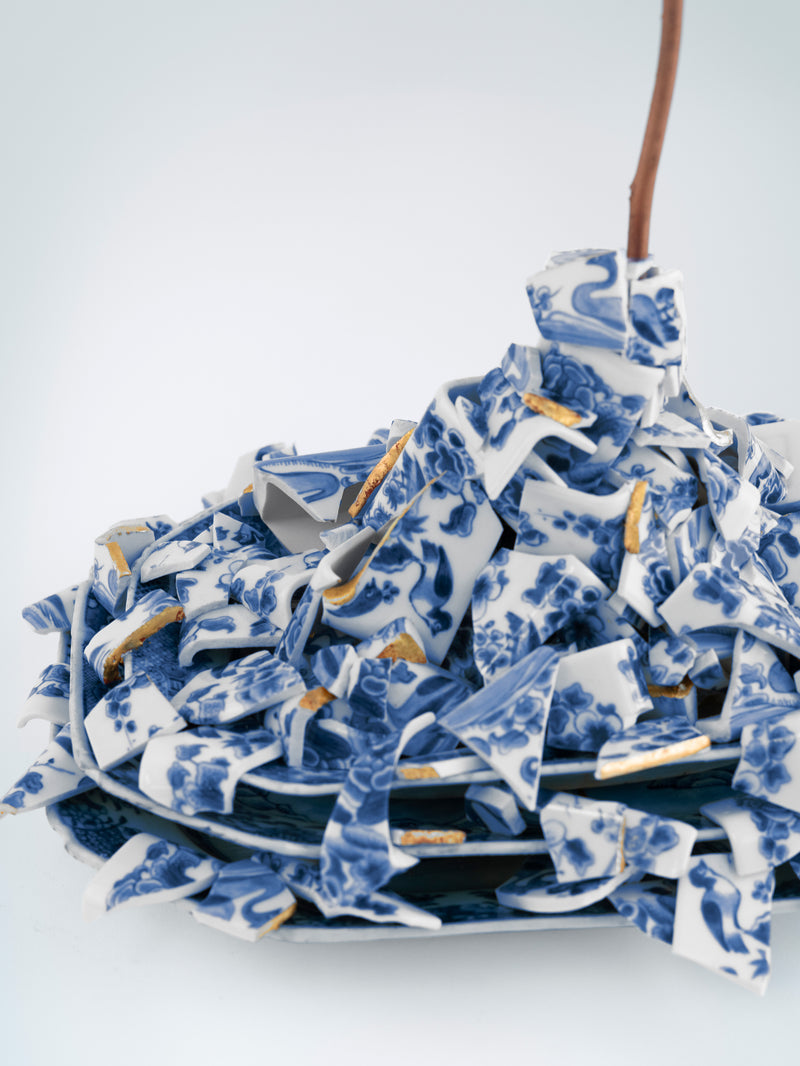 Stack of blue and white ceramic plates with floral patterns on a white background - Dries Van Noten