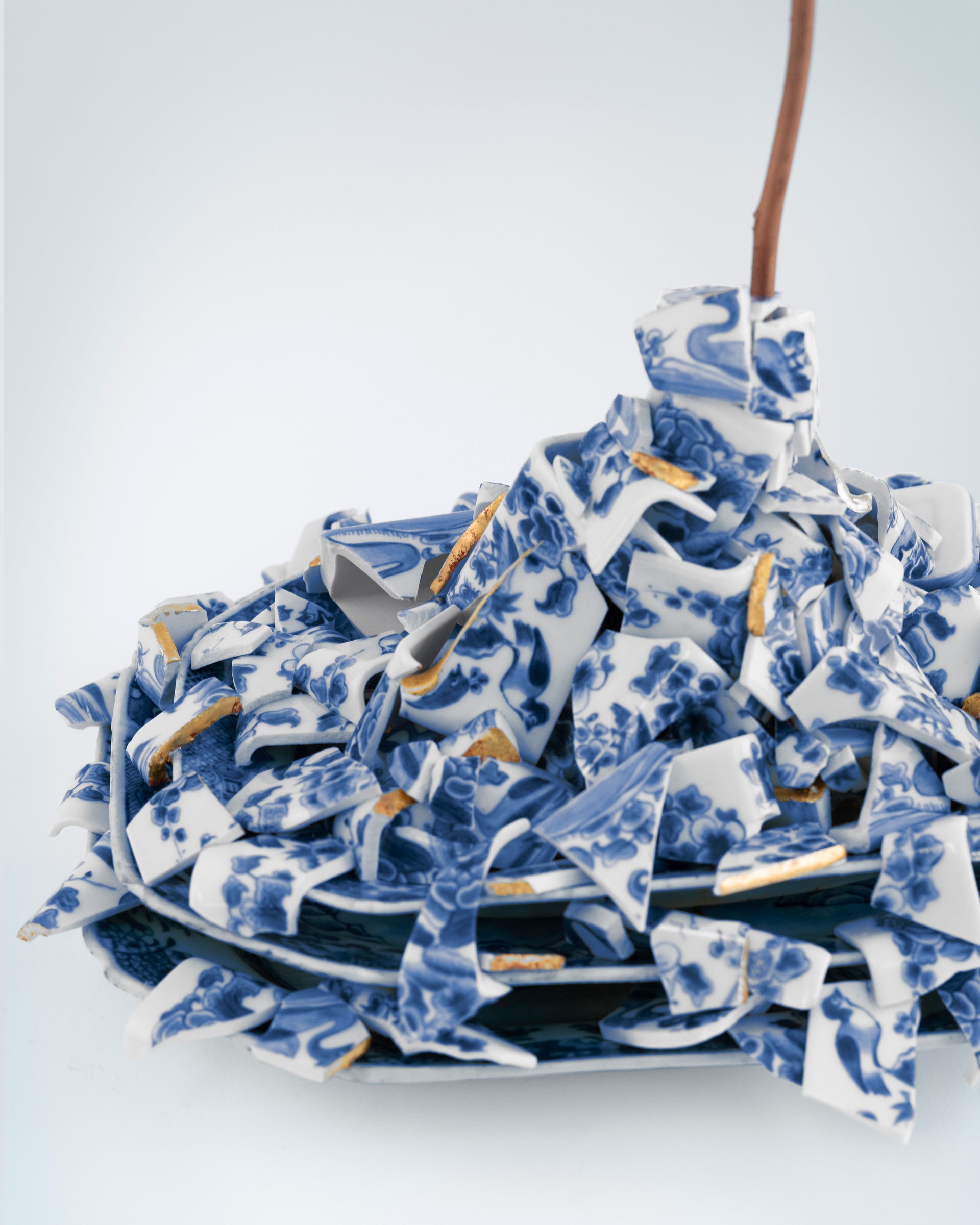 Stack of blue and white ceramic plates with floral patterns on a white background - Dries Van Noten