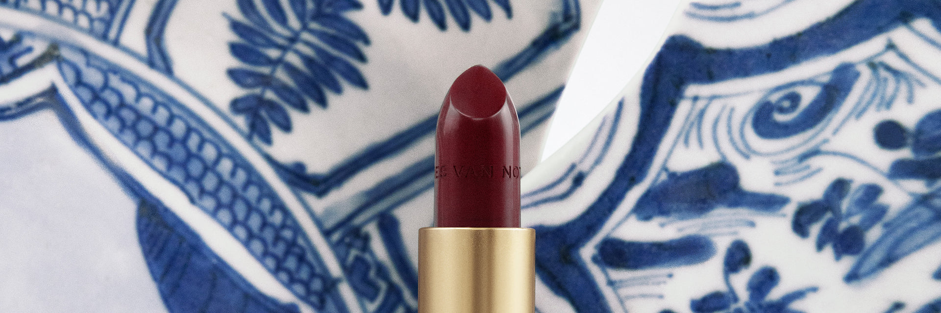 Red lipstick on a blue and white patterned background - Dries Van Noten