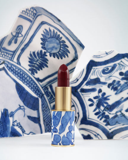 Lipstick with blue and white patterned case on a decorative plate - Dries Van Noten