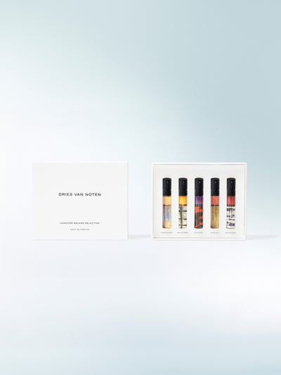 Set of five perfume bottles in a white box with 'Dries Van Noten' branding on a light blue background.