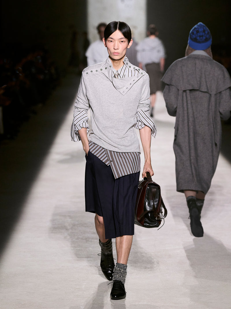 Model walking on a runway wearing a stylish outfit with a gray sweater and black skirt - Dries Van Noten