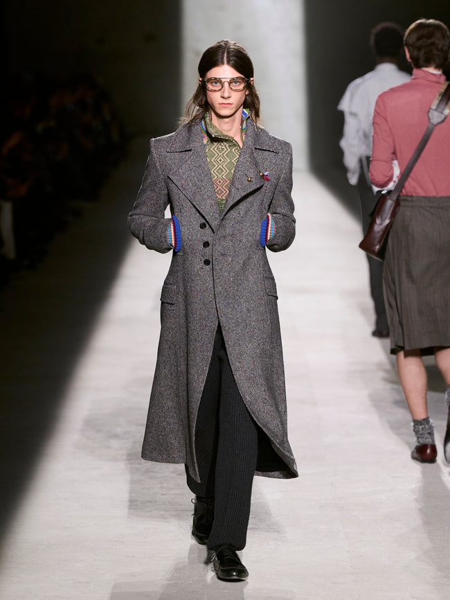 Model walking on a runway wearing a long gray coat - Dries Van Noten