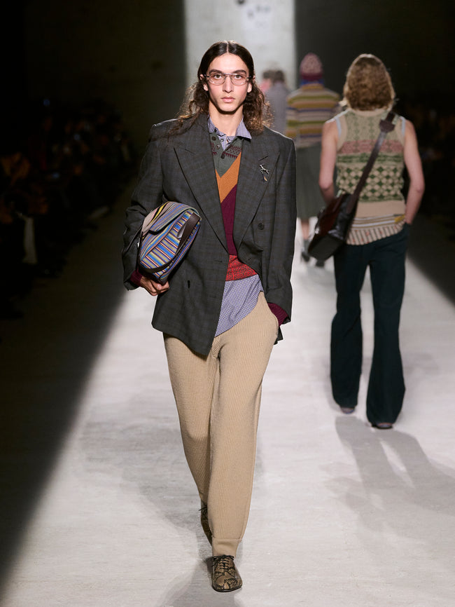 Model walking on a runway wearing a stylish outfit with a gray blazer and beige pants - Dries Van Noten