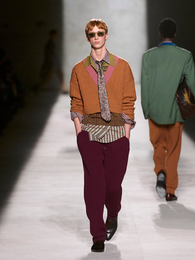 Model walking on a runway wearing a mustard sweater and purple pants - Dries Van Noten