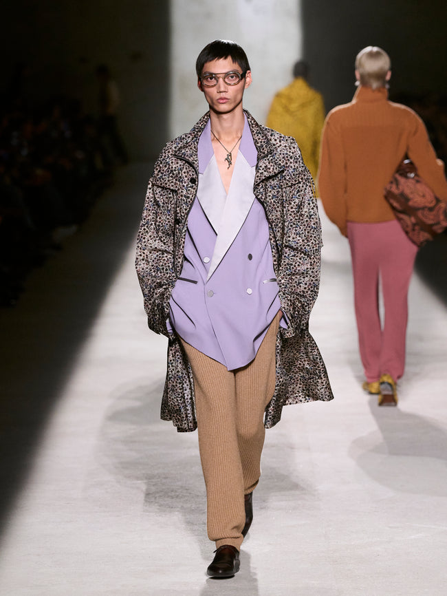 Model walking on a runway wearing a patterned coat and purple blazer - Dries Van Noten