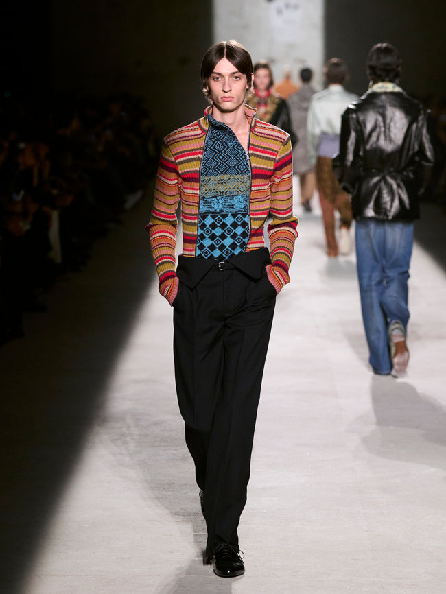 Model walking on a runway wearing a colorful jacket and patterned scarf - Dries Van Noten