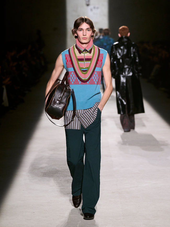 Model walking on a runway wearing a colorful outfit with a patterned vest - Dries Van Noten