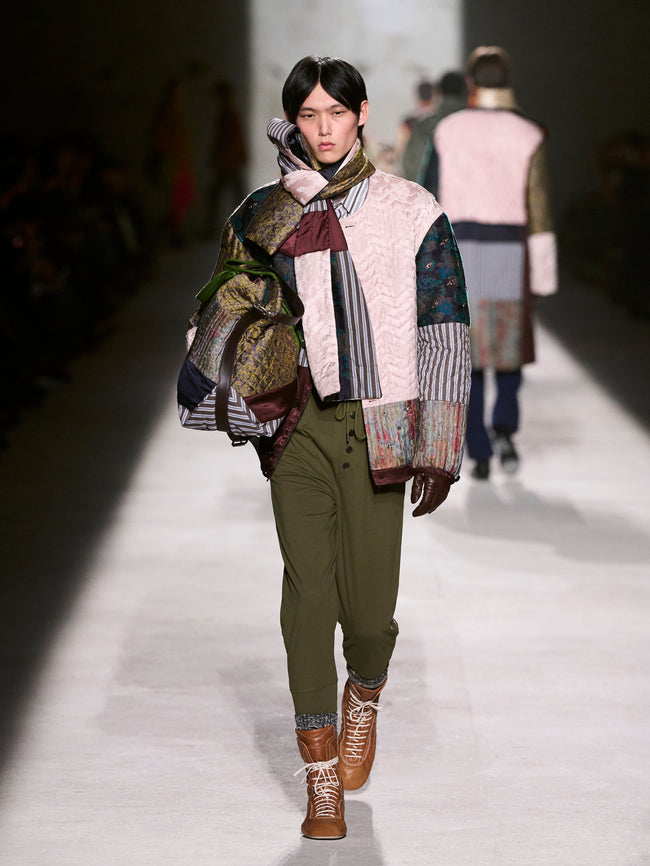 Model walking on a runway wearing a patchwork coat and green pants - Dries Van Noten